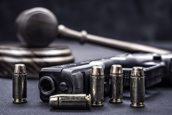 Photo of a gun with ammunition in front of gavel