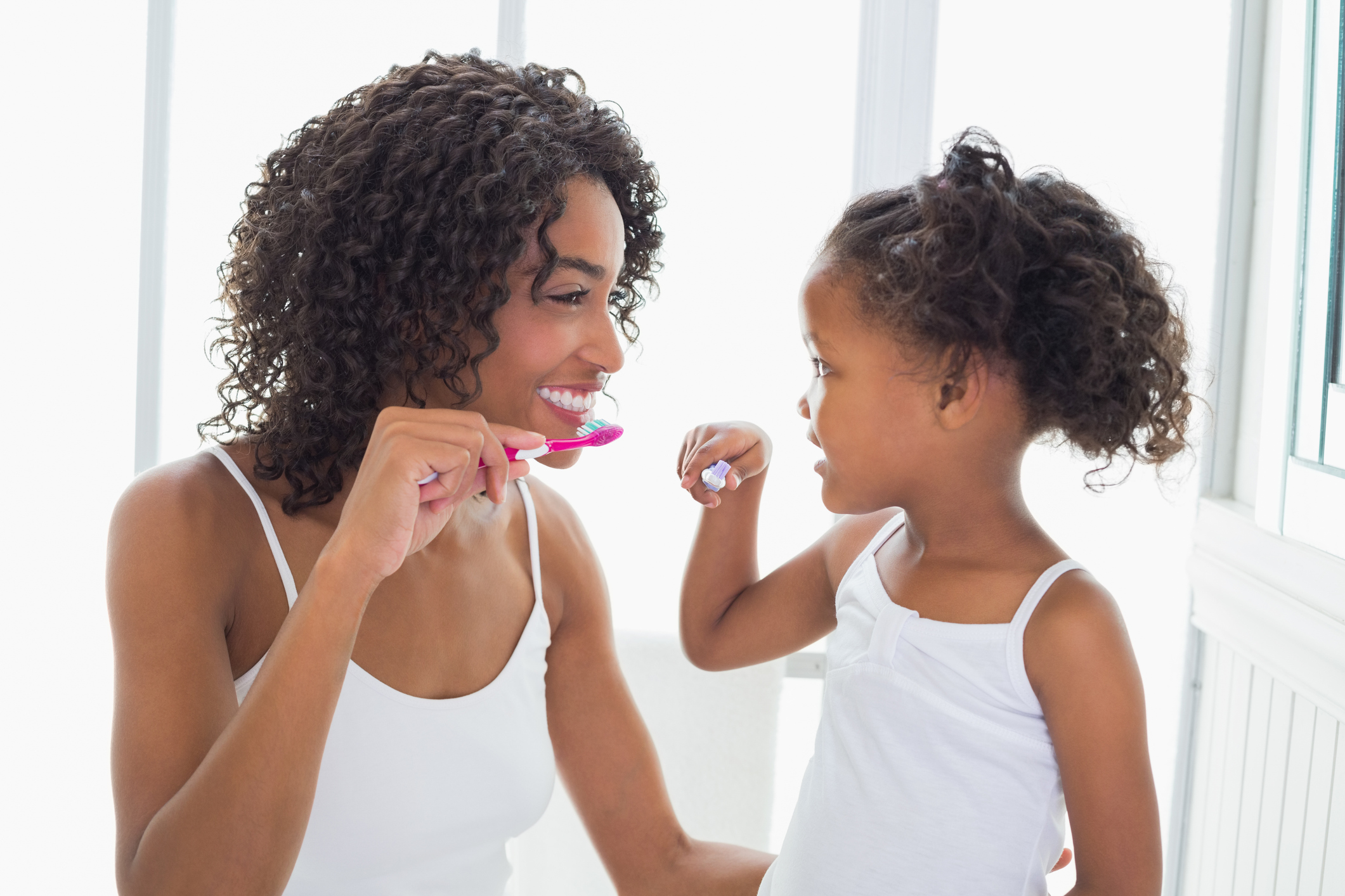 Child and mother brushing their teeth