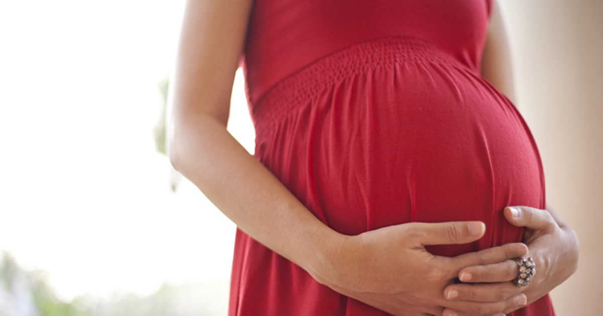 Photo of a pregnant woman holding baby bump