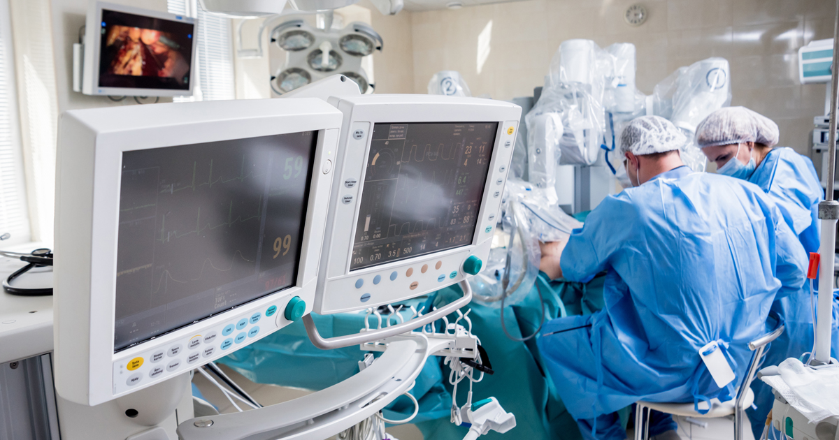 Photo of doctors in hospital performing surgery surrounded by health monitors