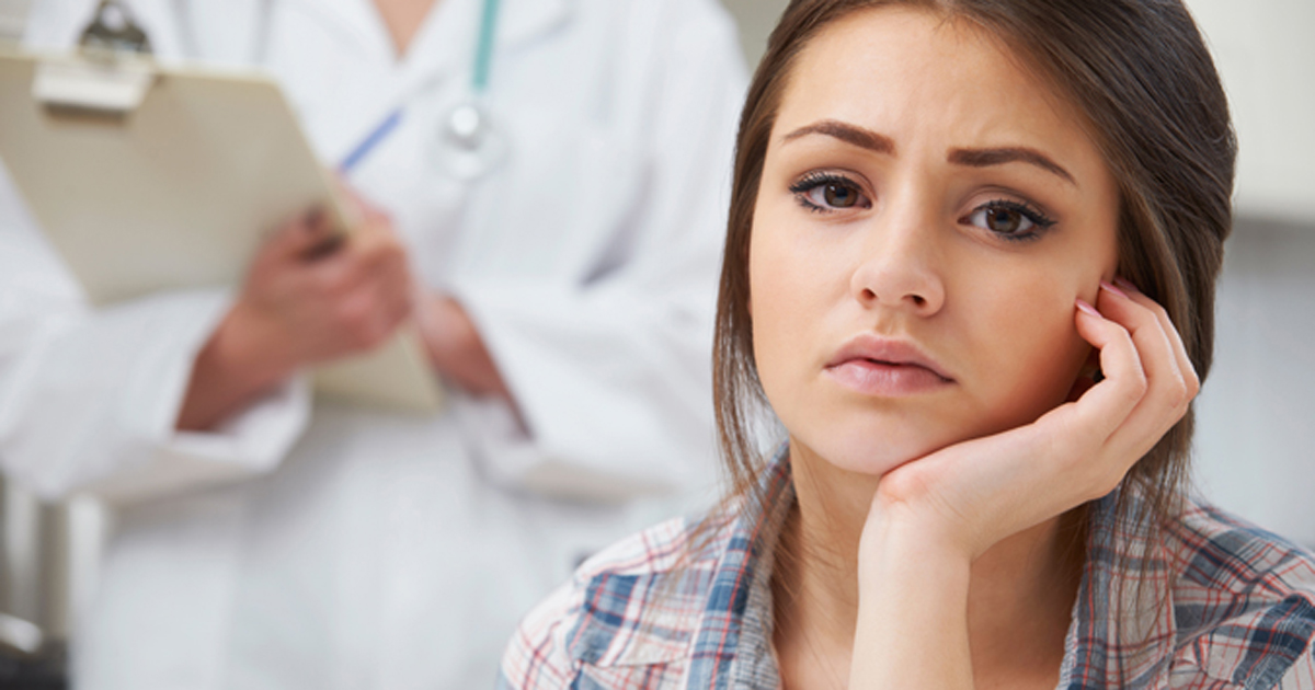 Photo of a teenage girl in a doctor's office with her doctor