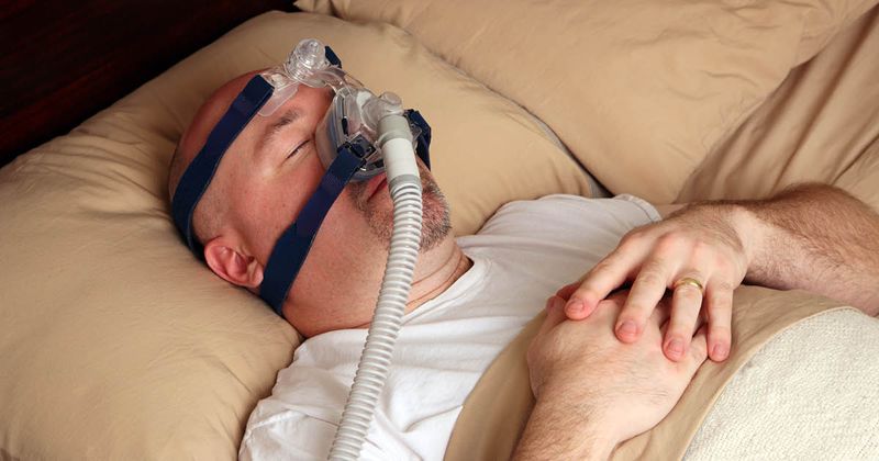 Man with sleep apnea using a CPAP machine.