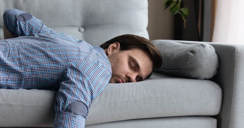 Man sleeping on couch during the day.