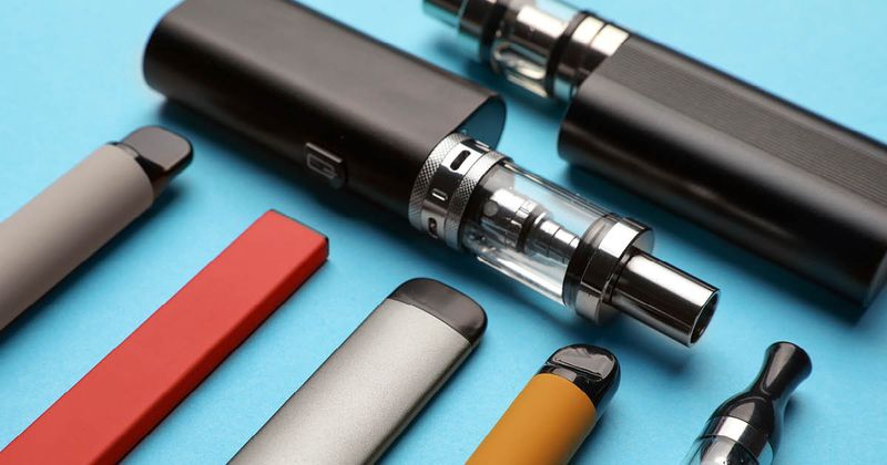 Different e-cigarettes on blue background.