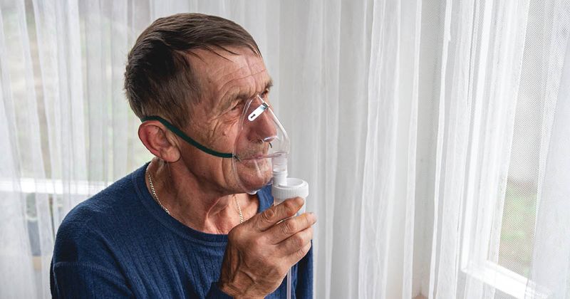 Elderly man wearing oxygen mask