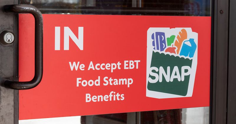 Door with sign that says, "We accept EBT food stamp benefits".