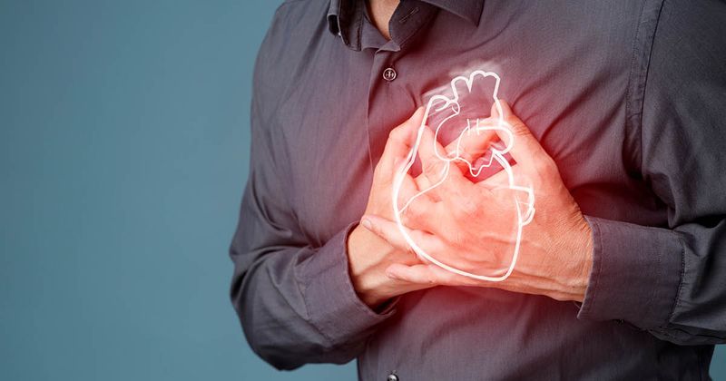 Man holding both his hands over his heart in pain.