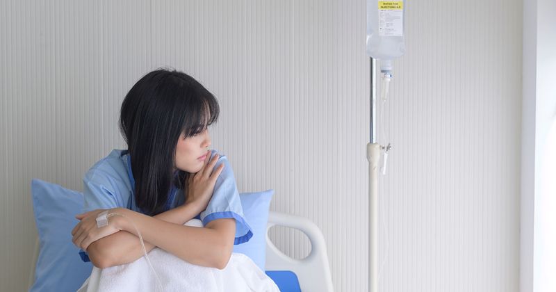 Asian woman in hospital bed