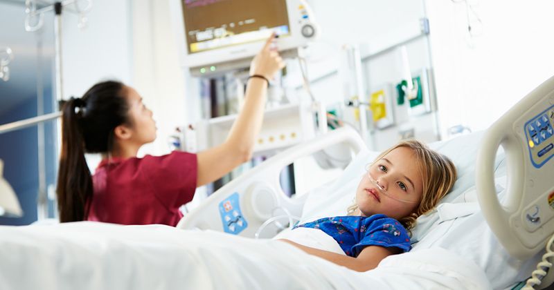 Young girl with nurse in ICU.