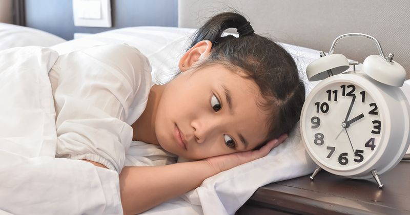 Young Asian girl suffering with insomnia or a sleep disorder