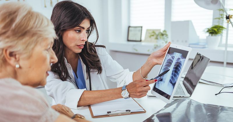 Doctor showing lung x-ray to patient.