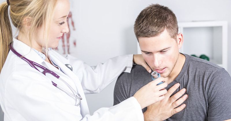 Doctor giving oxygen treatment to young male