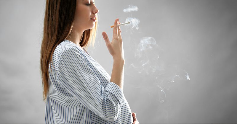 Pregnant woman smoking a cigarette.