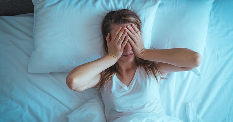 Women lying on bed suffering with sleep apnea