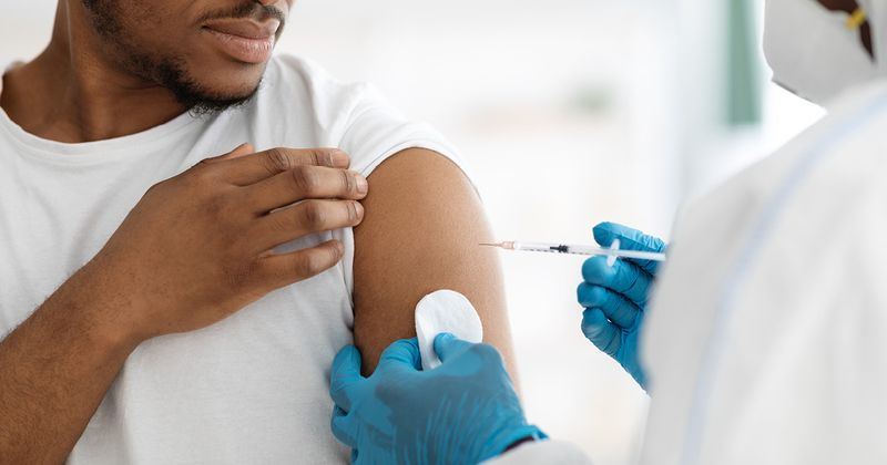 Black man receiving vaccine shot. 