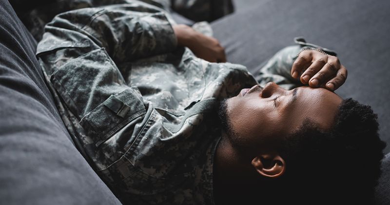 African American soldier sleeping in military uniform.