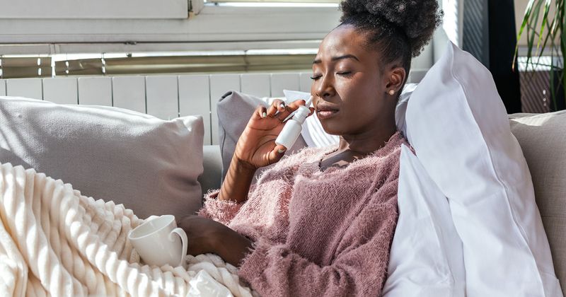 Photo of woman using nasal spray