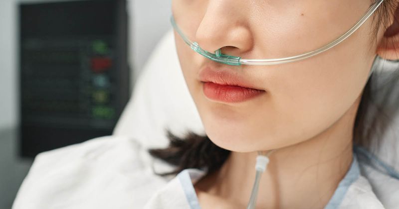 Image of woman in hospital bed wearing nasal cannula