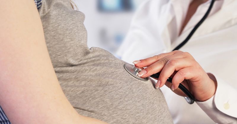 pregnant woman examined by doctor