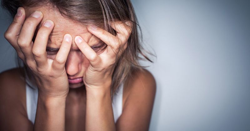 woman gripping forhead in aggravation