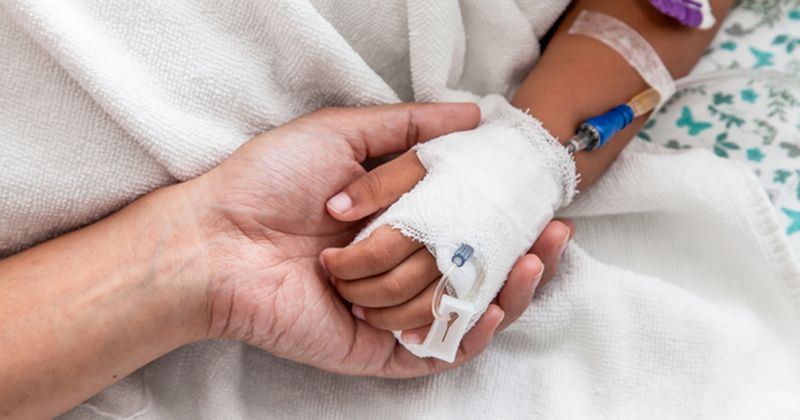 woman's hand touching child's hand