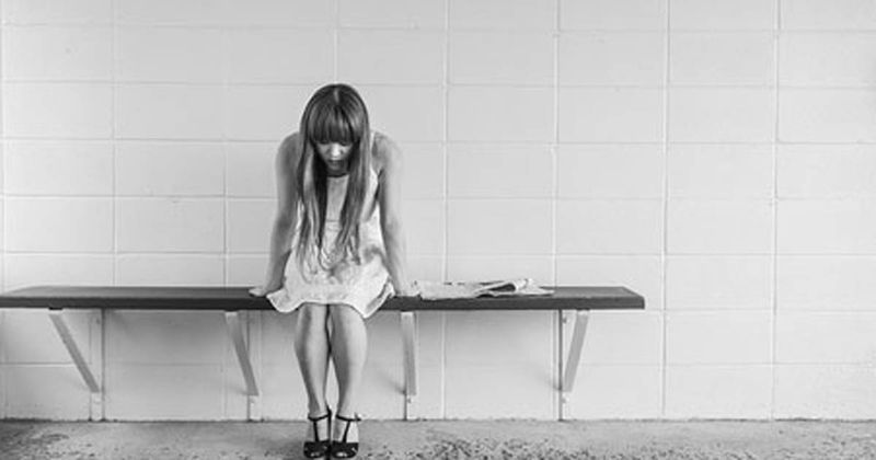 Sad woman on bench alone